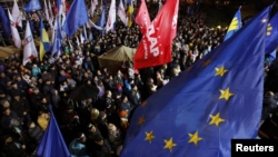 FILE - People attend a meeting to support EU integration at European square in Kyiv, Ukraine, Nov. 25, 2013.