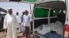 Ibrahim Gaidam, Governor of Yobe state, left, looks at bodies of students inside an ambulance outside a mosque in Damaturu, Nigeria, Tuesday, Feb. 25, 2014. Islamic militants killed dozens of students in a pre-dawn attack Tuesday on a northeast Niger
