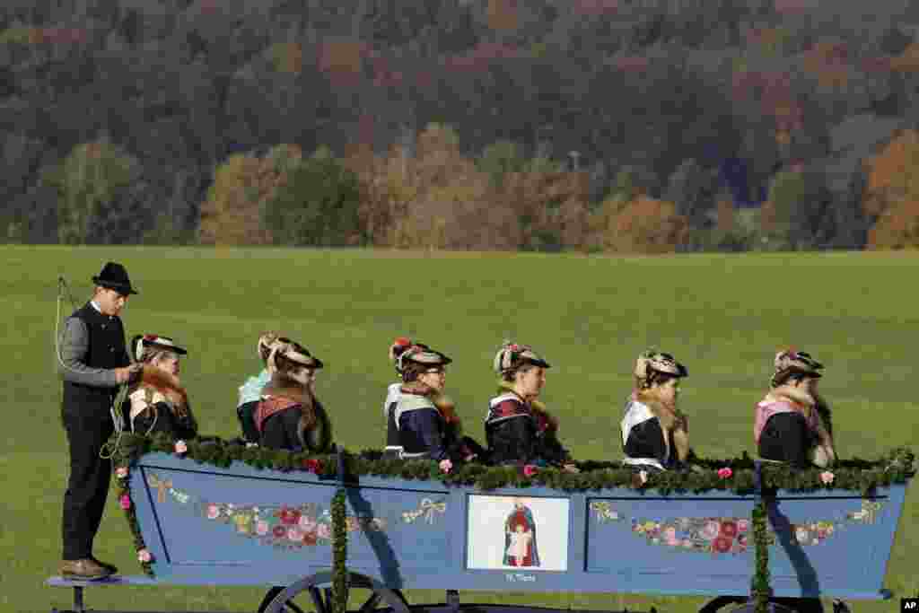Women in their costumes of the region sit in a horse-drawn carriage during the traditional Leonhardi pilgrimage in Warngau near Munich, Germany. The annual pilgrimage honors St. Leonhard, patron saint of the highland farmers for horses and livestock.