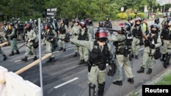 Petugas polisi anti huru-hara berpatroli di jalan selama protes anti-pemerintah di distrik Tai Po, di Hong Kong, Cina, 13 Oktober 2019. (Foto: Reuters/Ammar Awad)