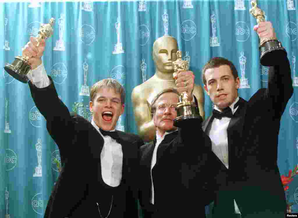 Oscar winners (L-R) Matt Damon, Robin Williams and Ben Affleck hold their Oscars for their work on the film "Good Will Hunting" at the 70th Annual Academy Awards, March 23, 1998, in Los Angeles. Damon and Affleck won for Best Screenplay Written Directly for the Screen and Williams won for Best Supporting Actor.
