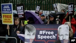 Supporters hold placards and banners during a protest against the extradition of Wikileaks founder Julian Assange outside Belmarsh Magistrates Court in London, Monday, Feb. 24, 2020. 