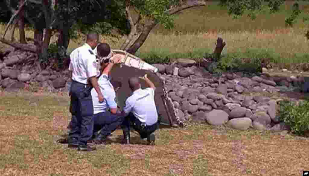 Des gendarmes et policiers français inspectent d'avion trouvé sur la plage de Saint-André, sur l'île française de l'océan Indien de la Réunion, 29 juillet 2015.