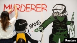 Pengunjuk rasa anti-pemerintah membuat mural yang menggambarkan pemrotes mahasiswa yang ditembak oleh polisi dari jarak dekat di Hong Kong, 2 Oktober 2019.