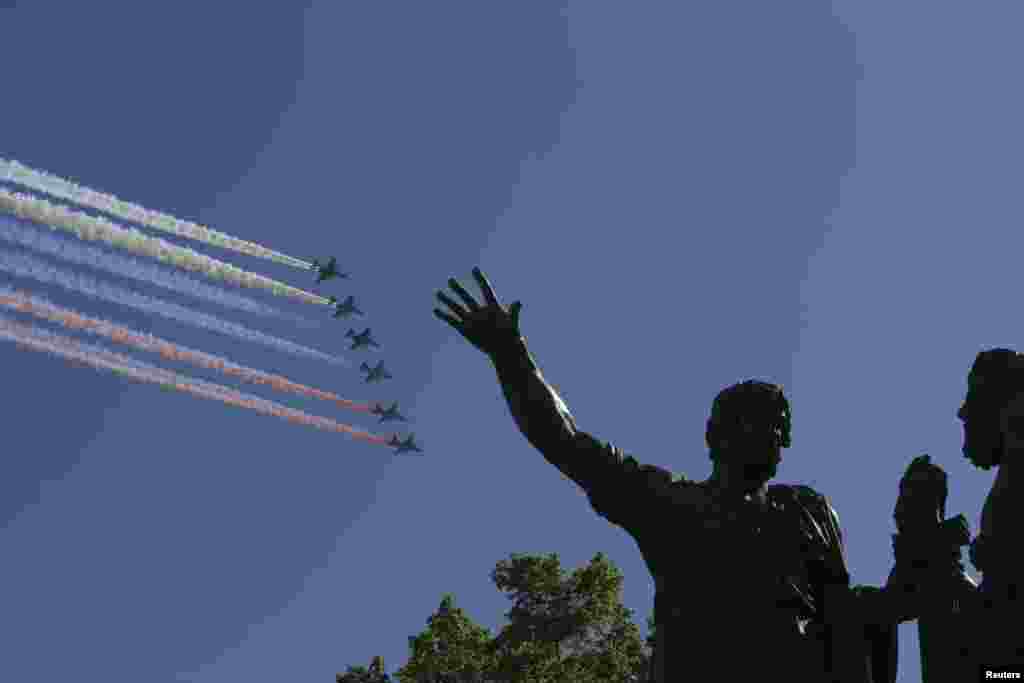 Pesawat terbang militer Rusia menyemburkan asap dalam tiga warna Rusia menghiasi angkasa di atas monumen Minin dan Pozharsky dalam parade Hari Kemenangan Rusia di Lapangan Merah, Moskow (9/5).