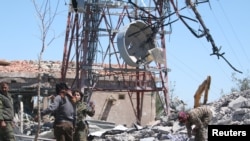Pejuang dari Unit Perlindungan Rakyat Kurdi (YPG) memeriksa kerusakan di markas mereka setelah terkena serangan udara Turki di Gunung Karachok dekat Malikiya, Suriah, 25 April 2017.