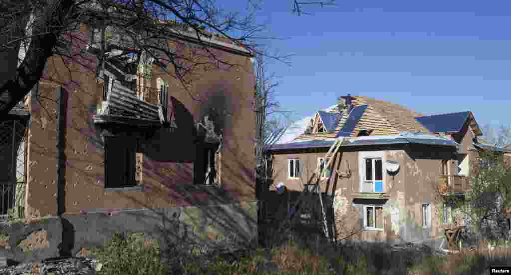 Workers repair the roof of a house damaged by recent shelling in the village of Semyonovka, near Slovyansk, eastern Ukraine, Oct. 27, 2014.