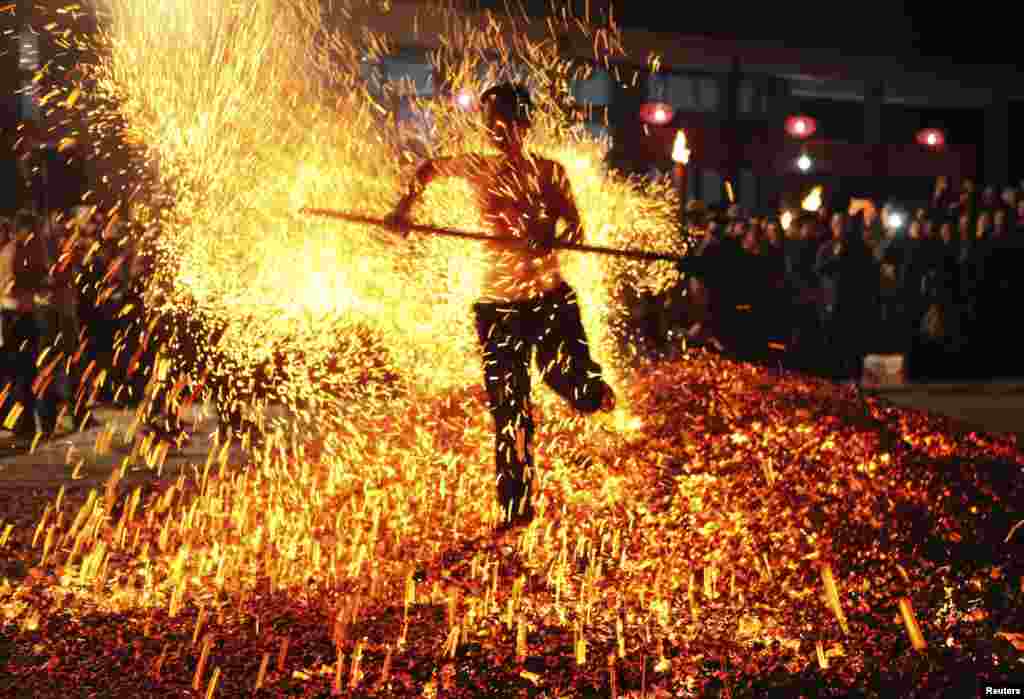 Seorang warga China melakukan ritual "Lianhuo", atau "berjalan menembus api" di kota Pan'an, provinsi Zhejiang, China.