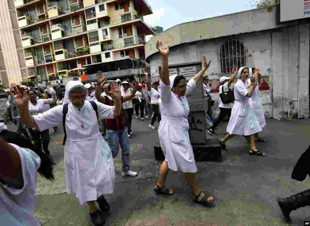 Nuns raise their arms during a women's march protesting repression against anti-government demonstrators in Caracas, Feb. 26, 2014.