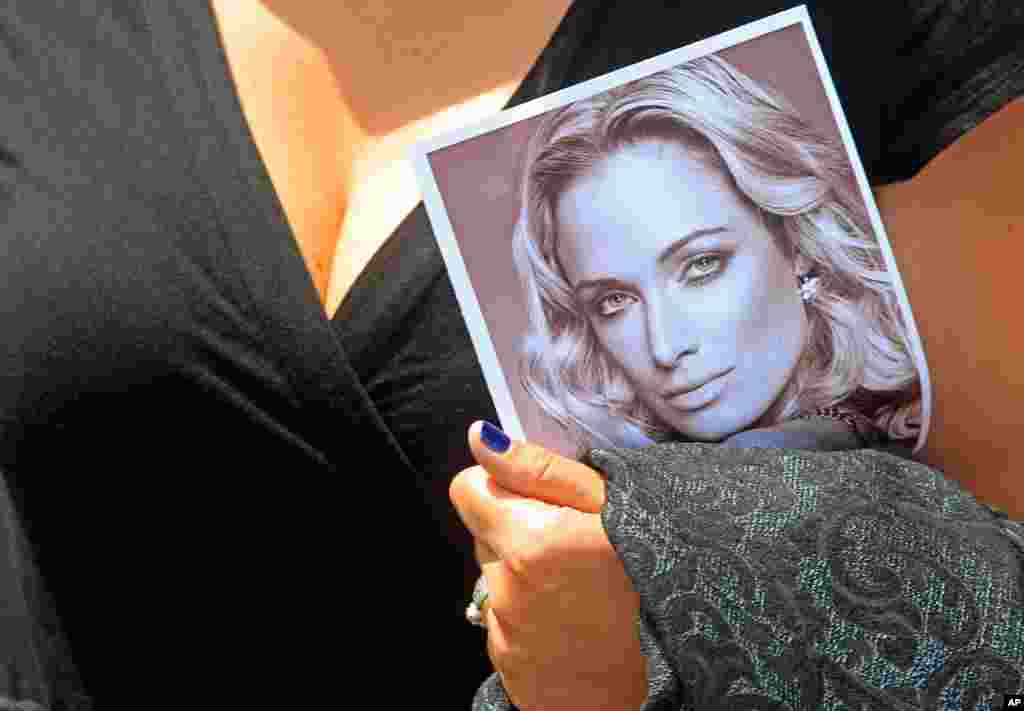 Một phụ nữ cầm ảnh của cô Reeva Steenkamp, người bạn gái của Pistorius thiệt mạng trong vụ nổ súng, ở thành phố Port Elizabeth. Nam Phi, ngày 19 tháng 2, 2013.