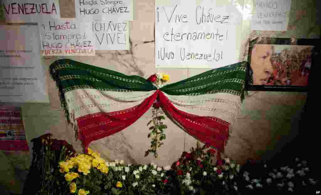 A mourning ribbon with the colors of the Mexican flag sits next to an image of Venezuela's President Hugo Chavez in front of Venezuela's embassy in Mexico City, March 5, 2013.