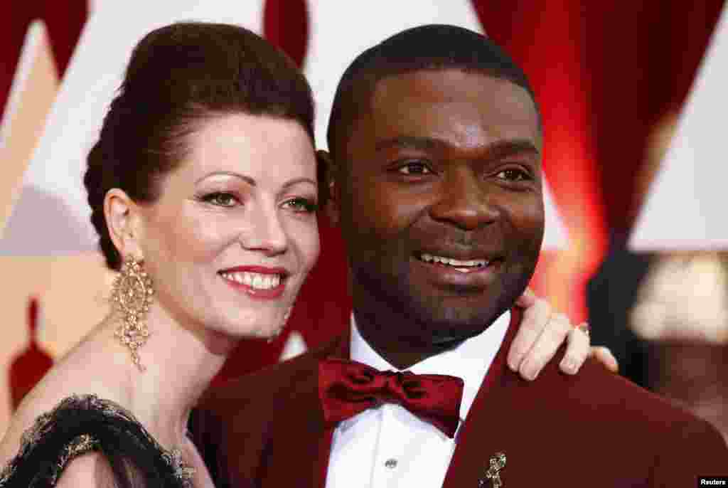 Actor David Oyelowo from the Best Picture nominated film "Selma" and his wife Jessica pose as he wears a "Tackle Ebola" pin on his lapel at the 87th Academy Awards in Hollywood, California, Feb. 22, 2015.