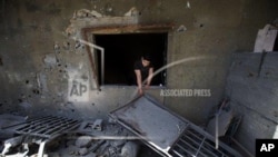 A Lebanese man removes debris from his damaged house, hit by rockets fired by Syrian rebels according to villagers, in Hermel town, northeast of Lebanon, Wednesday May 29, 2013. Shells fire from Syria regularly strike the Lebanese northeastern town of Her