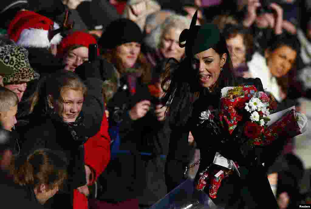 Puteri Catherine, the Duchess of Cambridge, mengumpulkan bunga-bunga dari warga Inggris yang mendoakannya pada hari Natal di gereja kota Norfolk, Inggris timur.