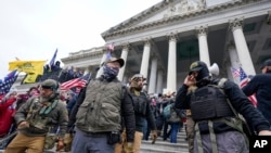 Wanachama wa kundi lenye itikadi kali ya mrengo wa kulia (Oath Keepers) wakisimama nje ya jengo la bunge la Marekani, Januari 6, 2021.