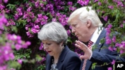 FILE - U.S. President Donald Trump talks with British Prime Minister Theresa May in Taormina, Italy, May 26, 2017. 