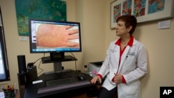 University of Miami dermatologist Dr. Anne Burdick checks the computer screen in her Miami office, as she discusses telemedicine, April 8, 2014.