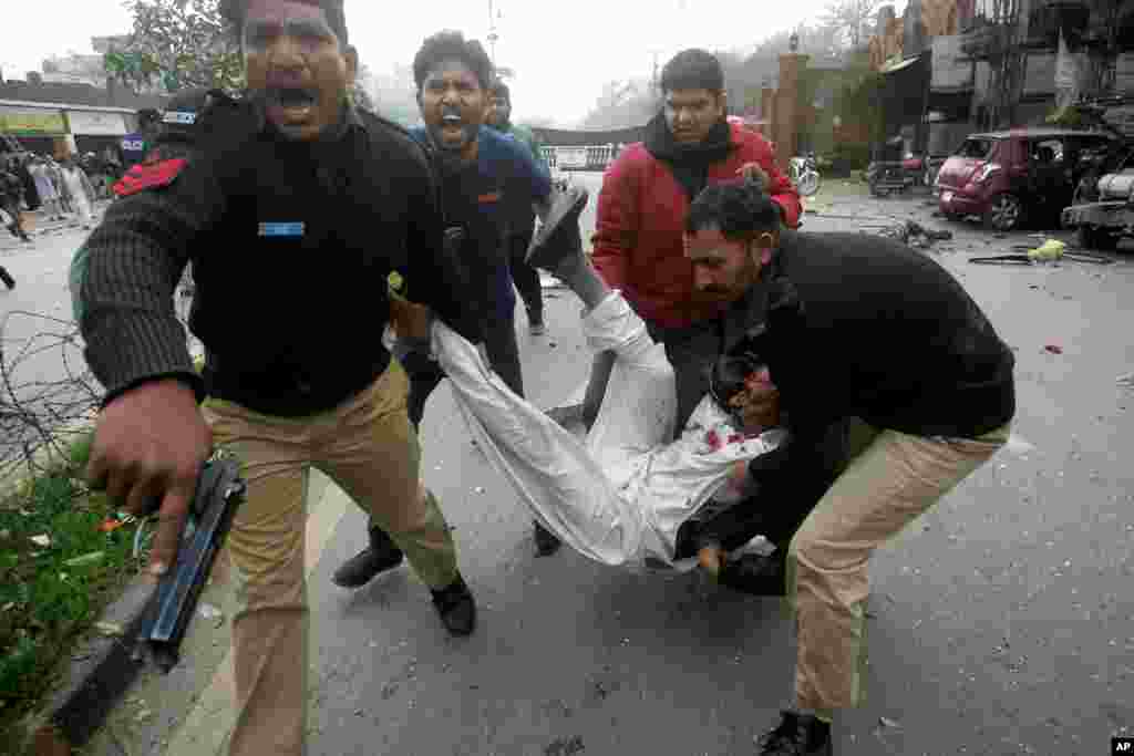 Pakistani police officers and volunteers rush an injured man to a hospital after a bombing in Lahore, Pakistan, Feb. 17, 2015.