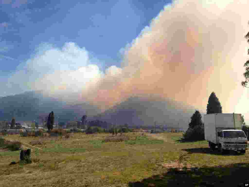 In this photo provided by the New South Wales Rural Fire Service, smoke rises from a fire near Lithgow, west of Sydney, Oct. 17, 2013.