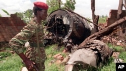 FILE - A Rwanda Patriotic Front (RPF) rebel walks by the the site of a April 6 plane crash which killed Rwanda's President Juvenal Habyarimana in this May 23, 1994 file photo in Kigali. 