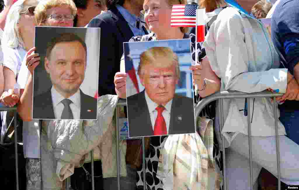 People hold images of Polish President Andrzej Duda and U.S. President Donald Trump during Trump's public speech at Krasinski Square, in Warsaw, July 6, 2017.