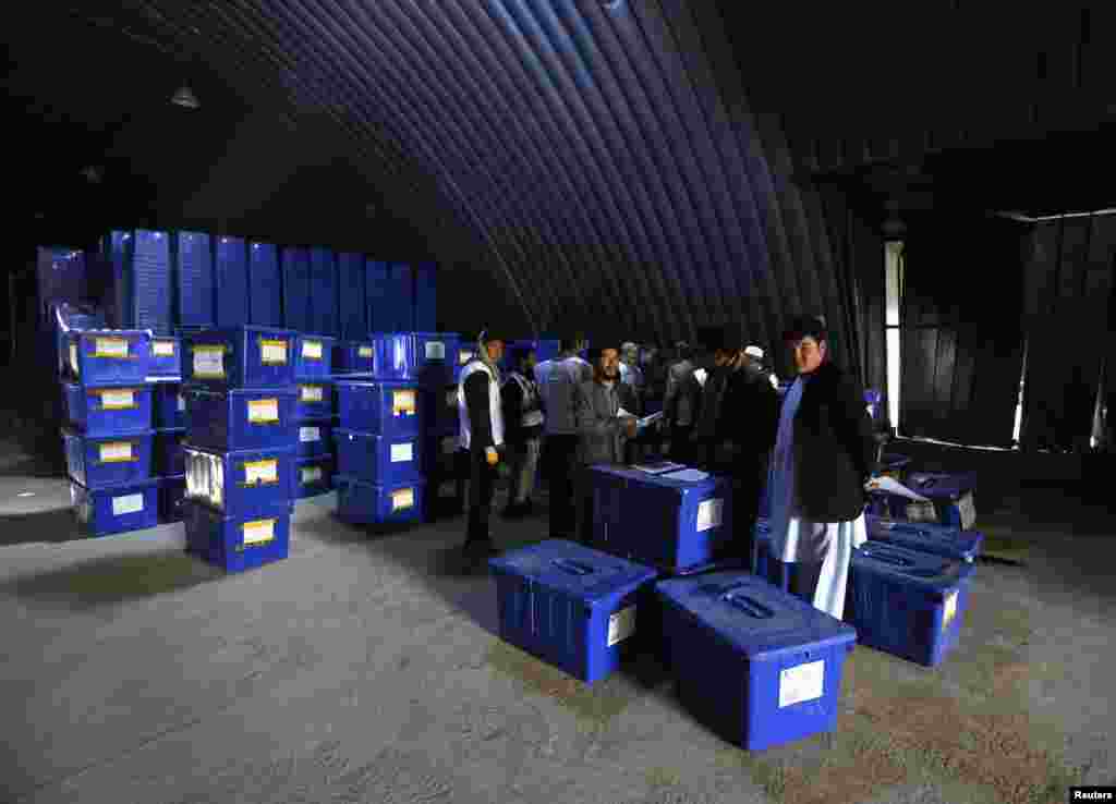Afghan election commission workers prepare to send ballot boxes and election material to the polling stations at a warehouse in Kabul, April 2, 2014.