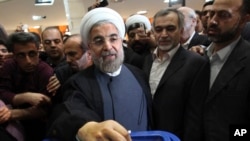 Presiden baru Iran Hassan Rowhani, mantan negosiator nuklir Iran, saat memberikan suara dalam pemilihan presiden (14/6). (AP/Vahid Salemi)