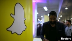 FILE - The logo of messaging app Snapchat is seen at a booth at TechFair LA, a technology job fair, in Los Angeles, California.
