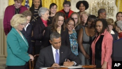 President Barack Obama signs executive actions, with pending Senate legislation, aimed at closing a compensation gender gap that favors men, Tuesday, April 8, 2014, in Washington, during an event marking Equal Pay Day.