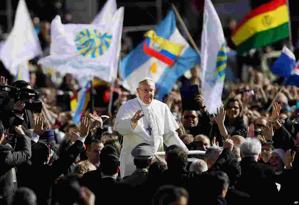 Pope Francis waves to crowds as he arrives to his inauguration Mass in St. Peter's Square at the Vatican, March 19, 2013. 