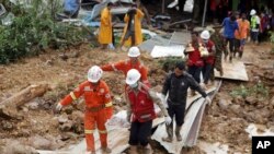 Members of a Myanmar rescue team carry a body at a landslide-hit area in Paung township, Mon State, Myanmar, Aug. 10, 2019. 