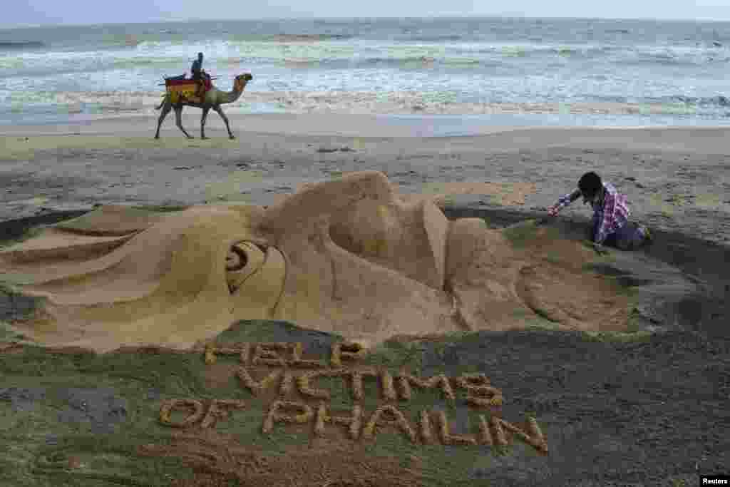 Sand artist Sudarshan Pattnaik works on a sculpture about Cyclone Phailin that hit Puri in the eastern Indian state of Odisha.