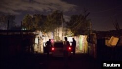 FILE - A man pleads with police officers to release a relative who they have just detained in Dandora during a night patrol in Nairobi, Kenya, Oct. 31, 2015. 