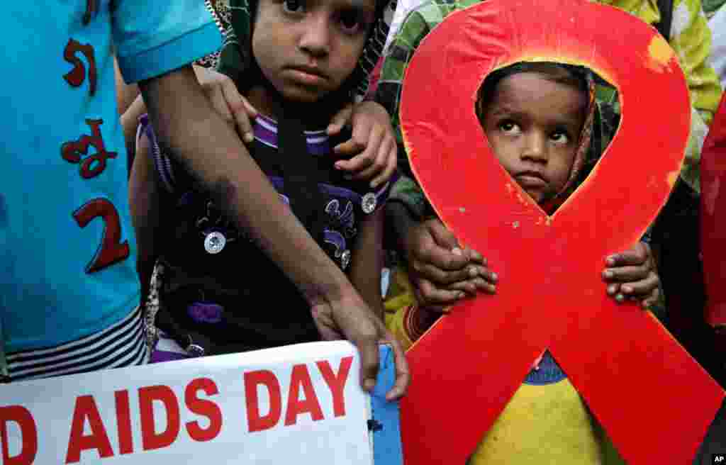 Children walk with activists in a torch light rally ahead of World AIDS Day in Kolkata, India, November 30, 2012. The activists demanded monthly pensions and free ration facilities for sex workers and HIV/AIDS-affected people.