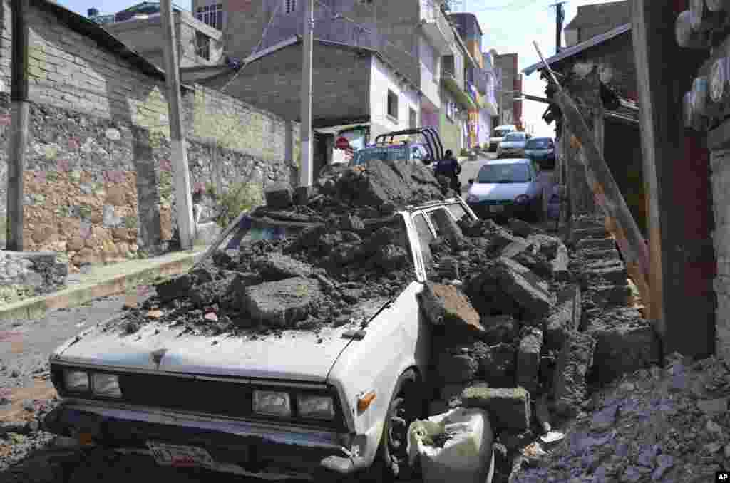 Sebuah mobil yang tengah diparkir mengalami kerusakan terkena reruntuhan dinding tembok setelah gempa besar mengguncang Chilpancingo, Meksiko. 