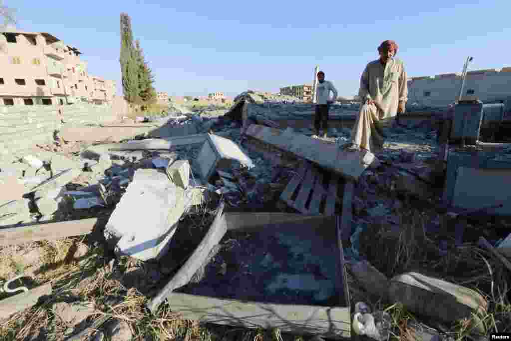 Abu Ismail, the owner of a plastics factory that was targeted on Sunday by what activists said were U.S.-led air strikes, examines the damage at his destroyed factory in the Islamic State's stronghold of Raqqa, Sept. 29, 2014.