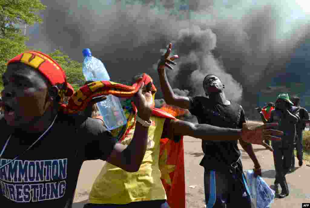 Hundreds of angry demonstrators storm parliament before setting it on fire to protest plans to change the constitution to allow President Blaise Compaore to extend his 27-year rule, Ouagadougou, Burkina Faso, Oct. 30, 2014.