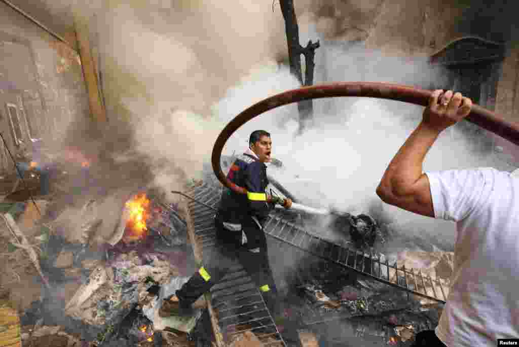 Firefighters extinguish fire at the scene of an explosion Beirut, Lebanon, October 19, 2012.