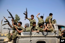 FILE - Shi'ite fighters, known as Houthis, ride on a patrol truck as they chant slogans during a tribal gathering showing support for the Houthi movement in Sana'a, Yemen, Dec. 2016.