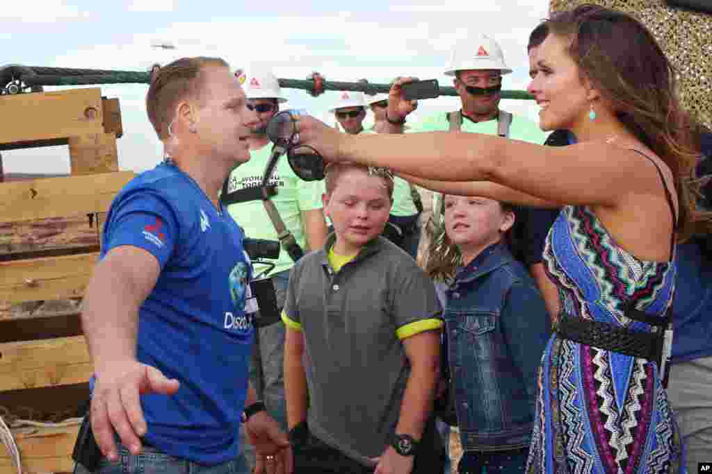 Aerialis Nik Wallenda (kiri) disambut istrinya Erendira, setelah berhasil menyeberangi ngarai Grand Canyon di atas kabel baja berdiameter 5 sentimeter tanpa jaring atau tali pengaman (23/6). (AP/Discovery Channel, Tiffany Brown)