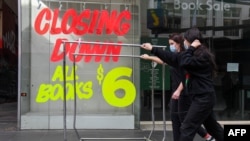 澳大利亚墨尔本商业区的行人走过关闭的商店。（2020年8月3日）