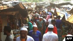 FILE - Rohingya refugees walk in the market area inside a refugee camp in Ukhia, Bangladesh, April 6, 2021.