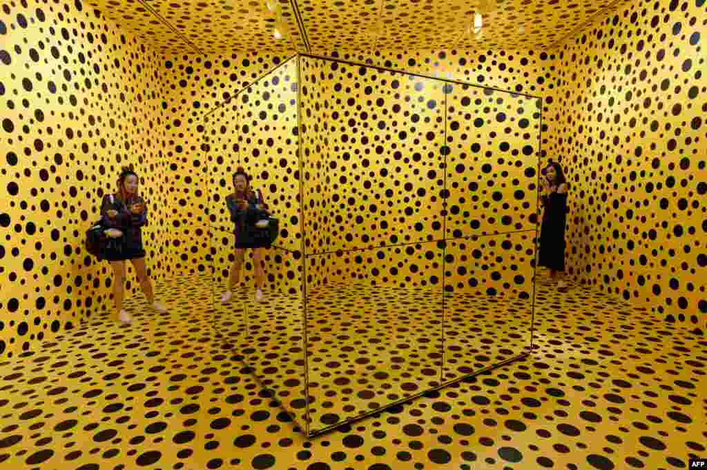 Para pengunjung berdiri di dekat sebuah karya seni oleh seniman Jepang Yayoi Kusuma yang dipamerkan di galeri nasional Singapura.