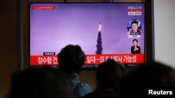 People watch a TV broadcasting file footage of a news report on North Korea firing a ballistic missile off its east coast, in Seoul, South Korea, October 19, 2021. (REUTERS/Kim Hong-Ji)