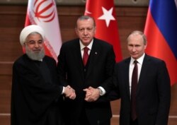 FILE - Presidents Hassan Rouhani of Iran, Recep Tayyip Erdogan of Turkey and Vladimir Putin of Russia hold a joint news conference after their meeting in Ankara, Turkey, April 4, 2018.