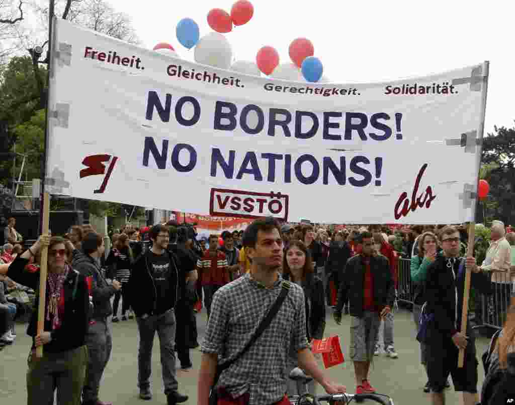 Para demonstran membawa spanduk bertuliskan "Kebebasan, Kesetaraan, Keadilan, Solidaritas. Tidak Ada Batas! Tidak Ada Bangsa!" dalam demonstrasi memperingati Hari Buruh di Wina, Austria (1/5). (AP/Ronald Zak)