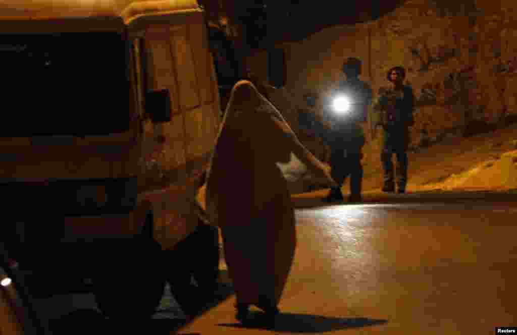 Seorang perempuan Palestina berargumentasi dengan tentara Israel di Tepi Barat kota Hebron, 15 Juni 2014.