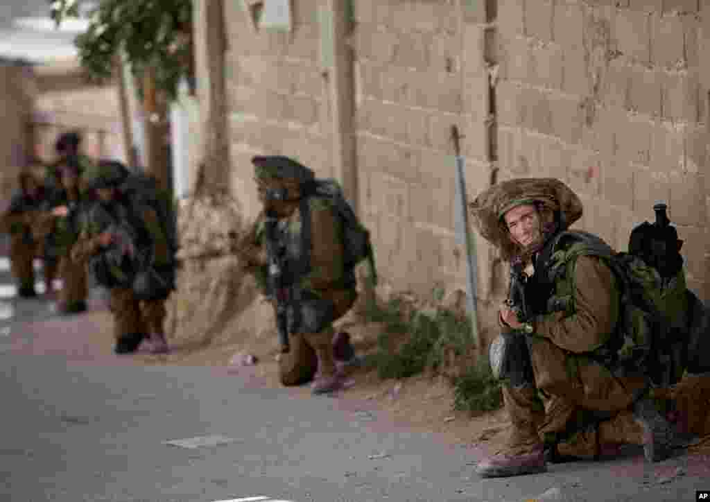 Tentara Israel mengambil dalam operasi militer untuk mencari tiga remaja yang hilang, dekat Tepi Barat kota Hebron, 15 Juni 2014.