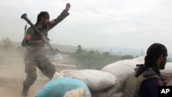 FILE - An Afghan National Army soldier shouts after firing a rocket toward Taliban positions on the outskirts of Kunduz, northern Afghanistan, April 16, 2016.