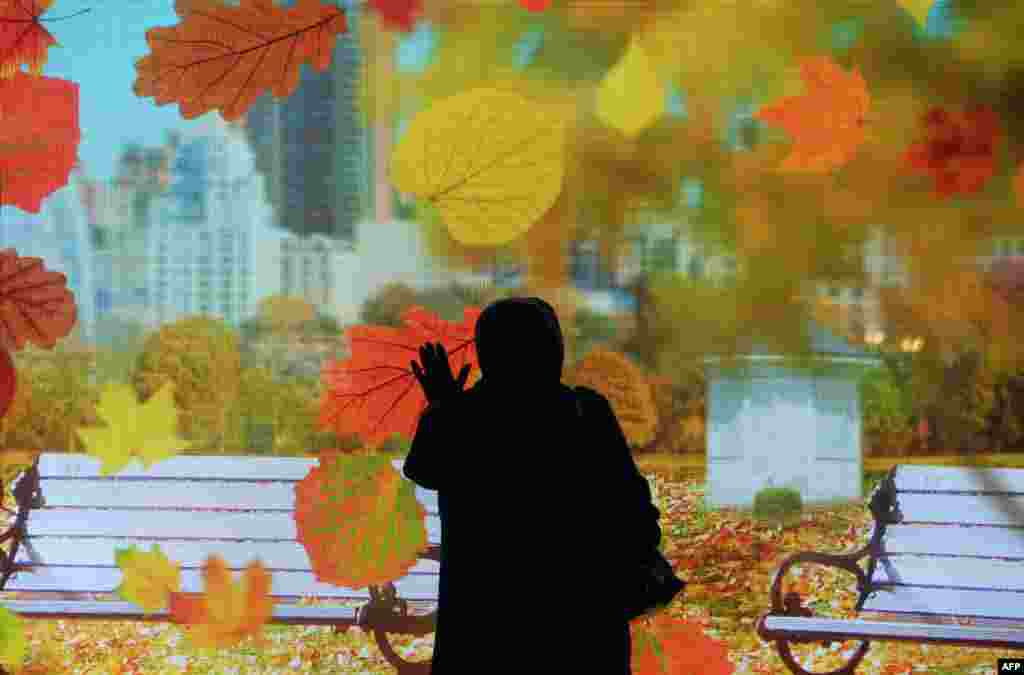A woman tries an outdoor advertising interactive touch screen in Moscow.